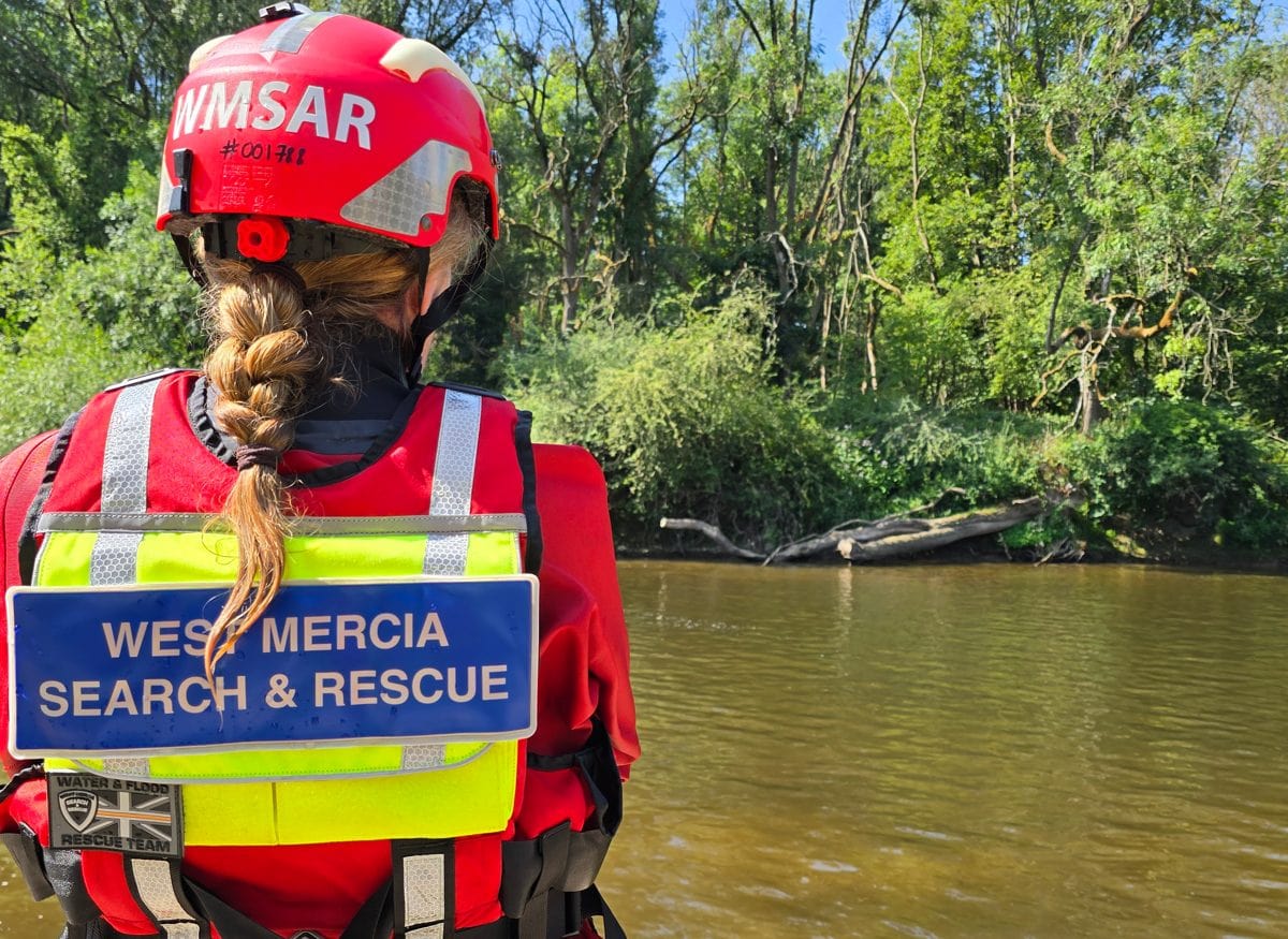 A WMSAR water rescue technician wading a river during a search